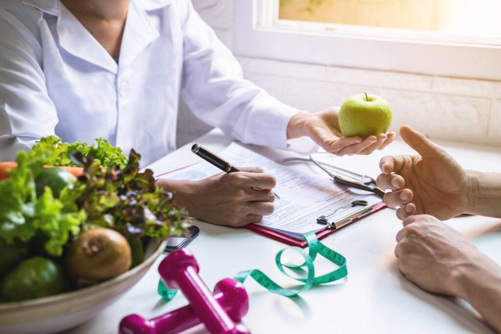 doctor-filling-out-form-with-patient-holding-apple